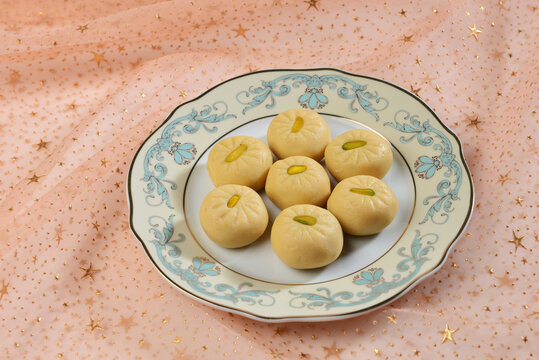 Milk Pedha- a favorite indian sweet served in an ornamental plate. Traditional Indian sweets and desserts.