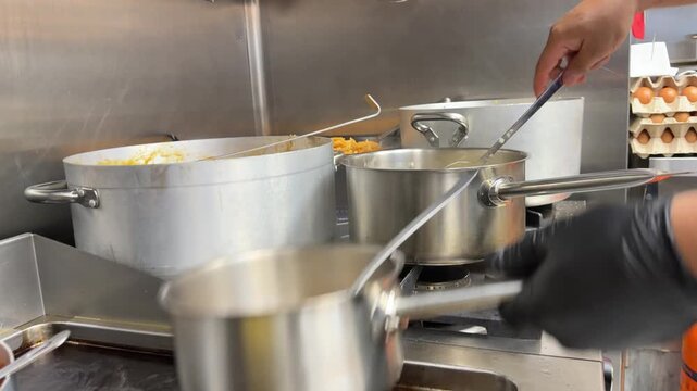 Chef pouring broth and lighting gas stove in commercial kitchen