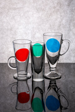 Still life with glass objects with colored spots on a reflective surface