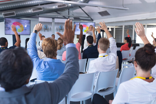 Audience raising their hands in a business conference