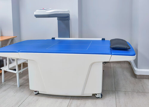 Bone densitometry scanner in an empty examination room. Osteoporosis screening and prevention. Medical imaging equipment for bone density testing. Diagnostic healthcare technology