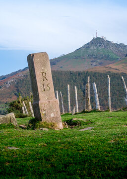 stone boundary marker at the border between France and Spain, with La Rhune, a highly symbolic summit in the French part of the Basque Country, in the background
