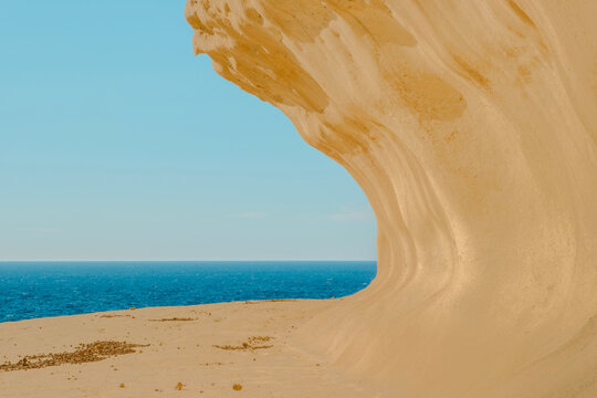 Natural Limestone Arch and Wind Eroded Sand Wave Sandstone Rock Formation in Gozo Coastline Framing the Deep Blue Mediterranean Sea, Malta