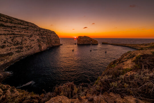 Sunset Landscape over Dwejra Bay Featuring Fungus Rock (Il-Gebla tal-General) and Anchored Sailboats in Calm Sea, Gozo Island, Malta