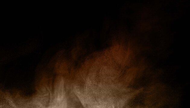 Dynamic explosion of golden brown powder and dust particles surging upward on a black background. Concept of abstract energy burst, special effect overlay, and dramatic texture.
