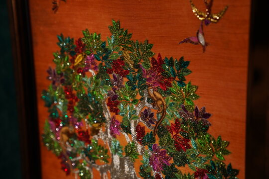 Vibrant Indian folk art featuring intricate metallic threadwork design