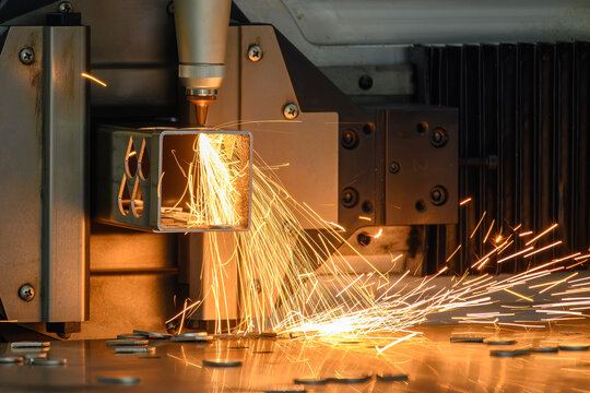 Splash of fire and sparks from a fiber laser cutting machine engraving a metal square tube