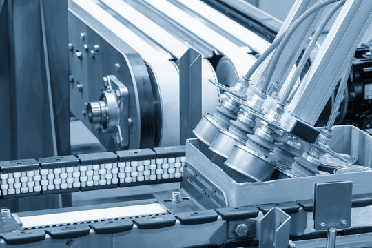 Automatic packaging process of canned food by a robotic system from a conveyor belt to a container box in a blue tone scene