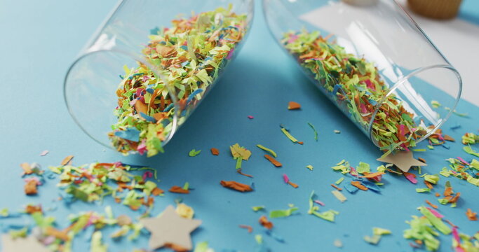 Champagne glasses with confetti and white card on blue background at new year's eve