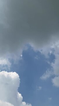 Time lapse of dark storm clouds gathering in a blue sky vertical video