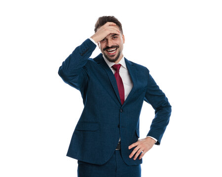 Astonished man in suit holding hand to forehead