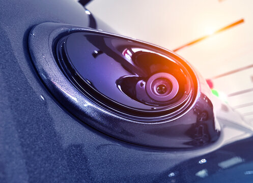 Vehicle parking sensor camera showing circular lens and mirror edge