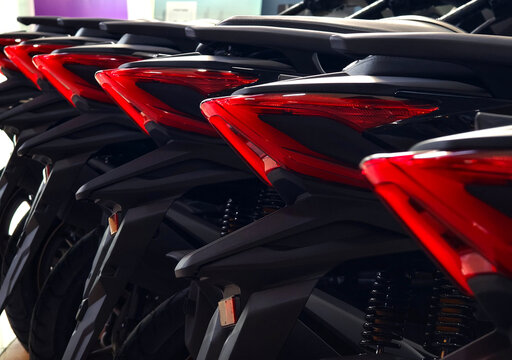 Row of black scooters lined up in indoor dealership showroom