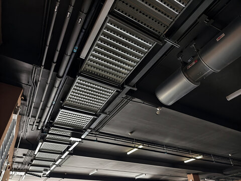 Exposed galvanized HVAC ducts and electrical conduit with bundled cables