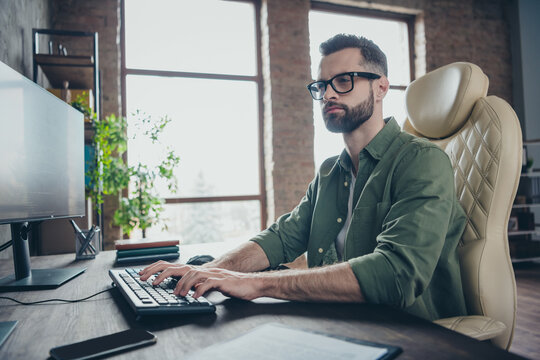 Portrait of attractive skilled focused brunet guy writing code solving issue task developing project start-up at work place station indoors