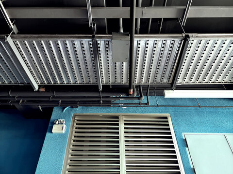 Exposed galvanized HVAC ducts and electrical conduit with bundled cables