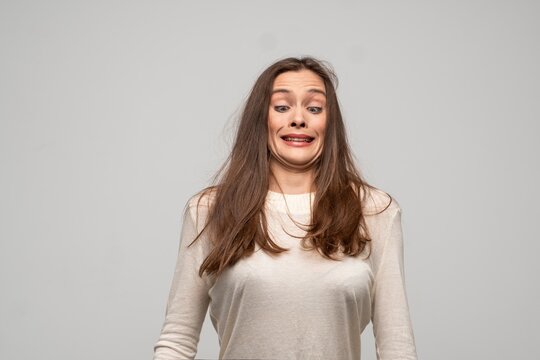 Woman making disgusted face, cringing from unpleasant odor or taste, feeling grossed out by something perceived