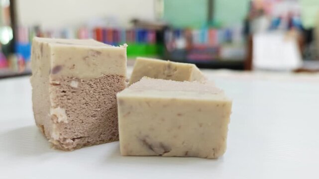 Delicious slices of taro chiffon cake with rich fudge topping arranged on the left.
