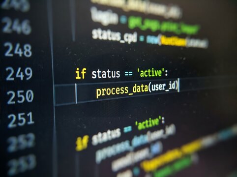 Programming code editor interface displaying if status active process data function on a dark computer monitor screen with visible pixel grid and shallow depth of field