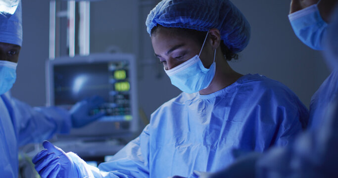 surgeons wearing protective clothing performing surgery in operating theatre