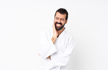 Young man doing karate over isolated white background with toothache © luismolinero