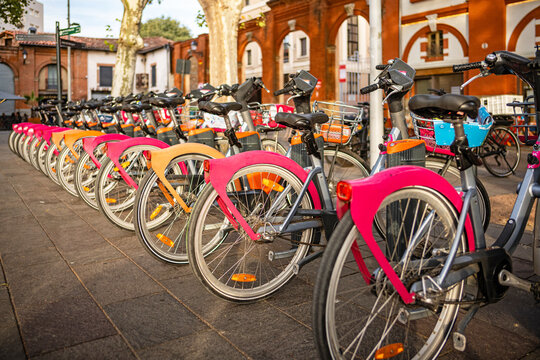 Toulouse, France &mdash; Pink and orange rental bikes at a rental station in downtown Toulouse