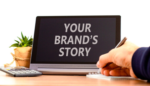Branding and your brands story symbol. Concept words Your brands story on beautiful black tablet. Beautiful white background. Businessman hand. Business branding your brands story concept. Copy space.