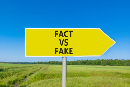 Fact vs versus fake words symbol. Concept words Fact vs Fake on beautiful yellow road sign. Beautiful blue sky green grass background. Business and fact vs versus fake concept. Copy space.