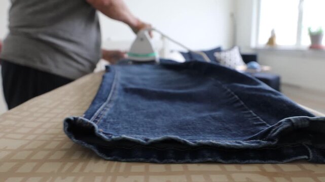 Stockholm, Sweden A woman irons clothes on an ironing board. 