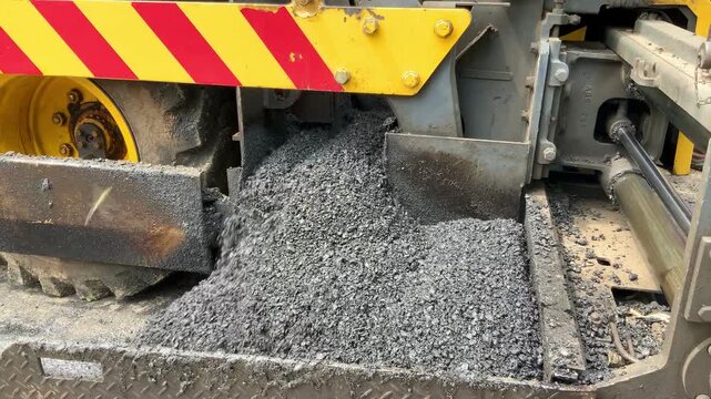 Industrial road construction machinery laying fresh asphalt on the highway