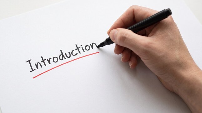 Hand writing Introduction with black marker on white paper underlined in red, beginning of report, essay or presentation concept