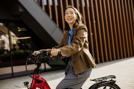 Sunlit ride on an electric bike beside modern city architecture