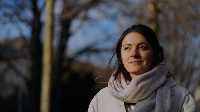 Portrait of a Caucasian woman smiling slightly in the late afternoon sun, optimism and self-assurance