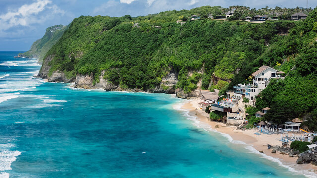 Drone view of turquoise beach and rolling waves along tropical shore