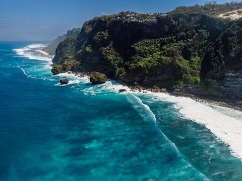 Landscape with rocky cliff coastline and blue ocean with waves. Drone view