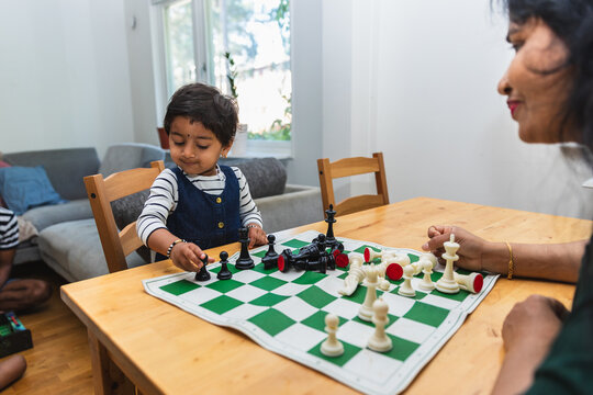Indian Toddler Girl Learning to Play Chess with Mother
