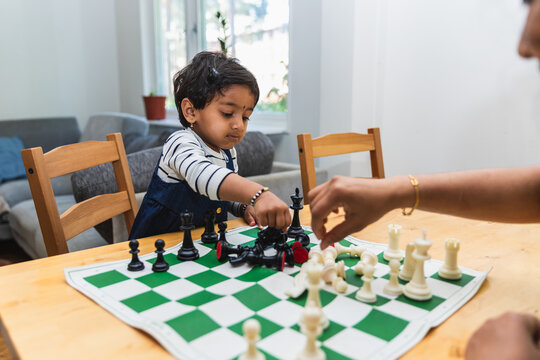 Indian Little Girl Moving Chess Piece on Board with Mother