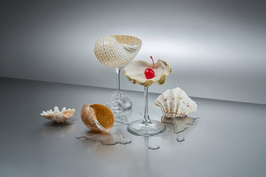 Seashells on glass stems with cherry, beach concept