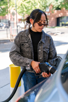 woman pumping gasoline at gas pump