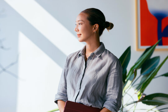 Professional Woman Standing Confidently In Modern Office Space
