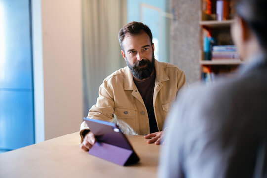 Businessman Using Tablet During Casual Business Meeting