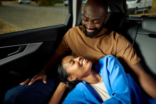 Two people in love are traveling in the back of a car.