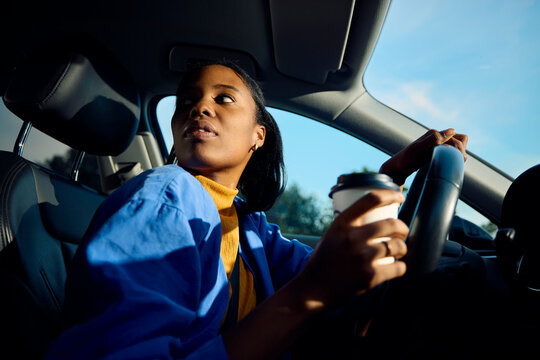 Woman drives a car with, looking over her shoulder