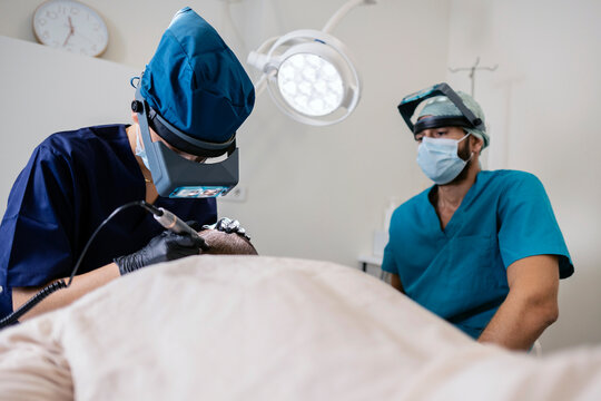 Surgeons performing hair transplant using advanced fue technique