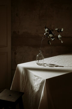 Still Life Composition of a Vase With Branches on a Table
