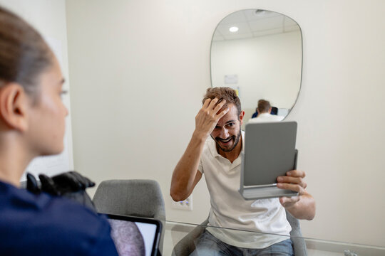 Man happy looking at hair treatment results