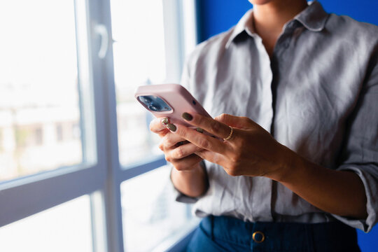 Businesswoman Using Smartphone Near Window