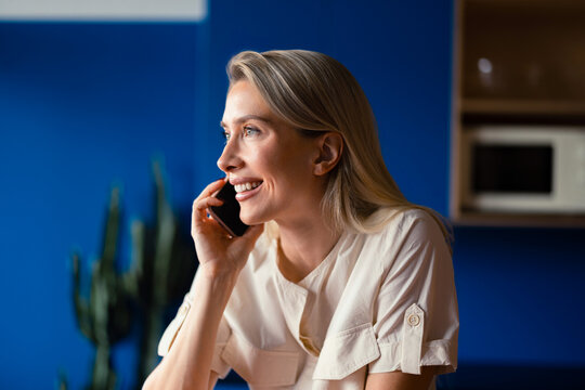 Smiling Woman Talking On Phone In Modern Office