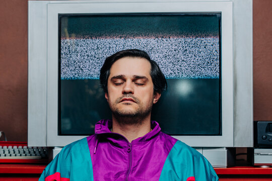 Relaxed retro man with eyes closed in front of static television screen