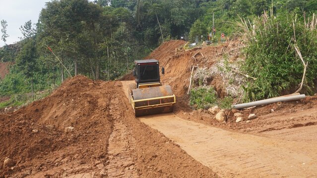 Road Roller Compactor Working on Earth Road at Construction Site in Forest Area